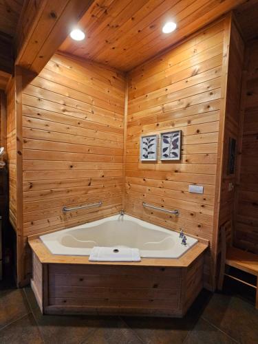 une baignoire jacuzzi dans une chambre avec des murs en bois dans l'établissement Honey Bear Haven Suite 3, à Eureka Springs