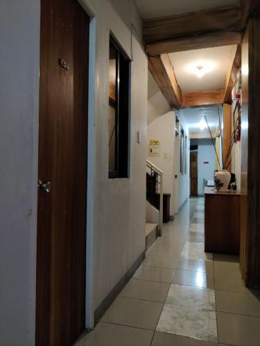 a hallway of a house with a kitchen and a door at Center Parkway Pension House in Kalibo