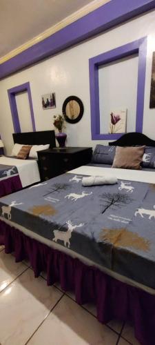 two beds in a room with at Center Parkway Pension House in Kalibo