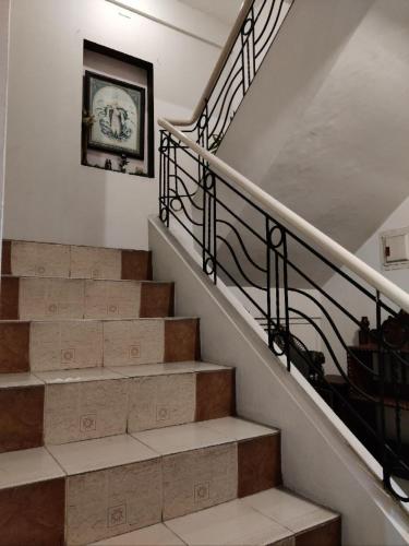 a staircase with a clock on the wall and a clock at Center Parkway Pension House in Kalibo