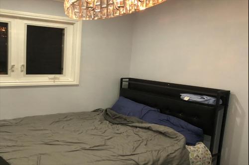 um quarto com uma cama, uma janela e um lustre em ShayCozyDelux-Room-102 em Pickering