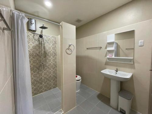 a bathroom with a shower and a toilet and a sink at Inn Dulgence in Patong Beach