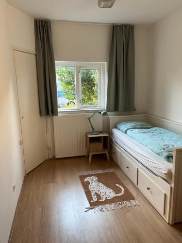 a small bedroom with a bed and a window at huize Louwra in Egmond-Binnen