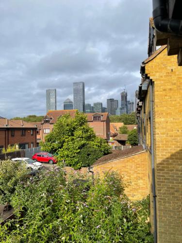 a red car parked in a parking lot with buildings at 2 Bed Flat Privite in Canada Water in London