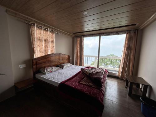 1 dormitorio con cama y ventana grande en Swabhumi Homestay, en Kurseong