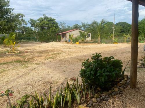 a dirt yard with a house in the background at Cabañas Paulamar - Tolu in La Gloria
