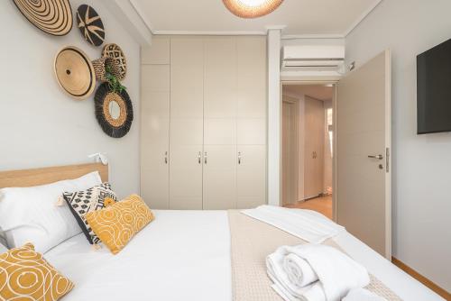a bedroom with a white bed with pillows and a tv at The Luxury Loft by Cloudkeys in Athens