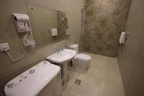 a bathroom with a sink and a toilet and a mirror at فندق ايليت الشرق in Jeddah