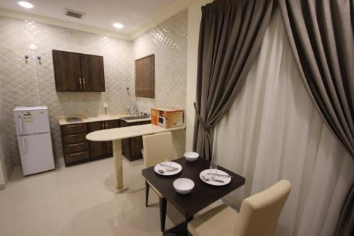 a kitchen with a table and chairs and a kitchen with a tableablish at فندق ايليت الشرق in Jeddah