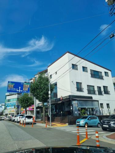 un edificio bianco in una strada di città con auto parcheggiate di Food House a Andong