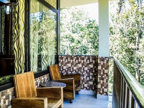 una veranda schermata con 2 sedie e un tavolo di River Rock Homestay a Anachal