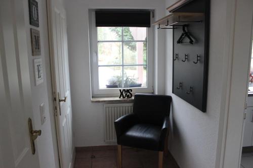 a black chair in a hallway with a window at Ferienhaus an der Grenze zu Hamburg Zentrale Lage in Neu Wulmstorf