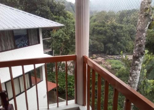 a balcony with a view of a tree at River Rock Homestay in Anachal