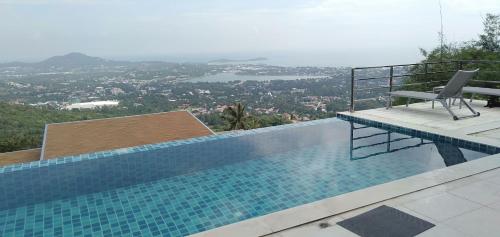 a swimming pool with a chair sitting on top of it at Great Sea View Mountain Villa Koh samui in Amphoe Koh Samui