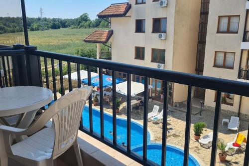 a balcony with a pool and a table and chairs at Apartment Oasis A4 Kamchia in Bliznatsi