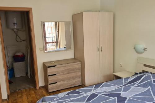 a bedroom with a bed and a dresser and a mirror at Apartment Oasis A4 Kamchia in Bliznatsi