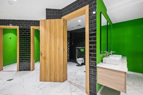 a bathroom with a sink and a green wall at Hidden Gem Studio - Affordable in Dubai