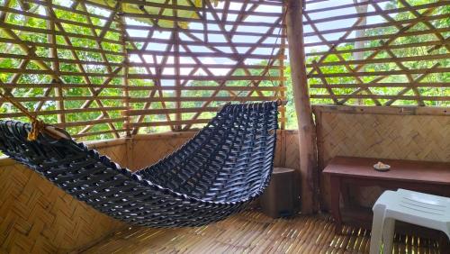 two hammocks on a porch with a roof at Erlittop Garden Eco Lodge in El Nido