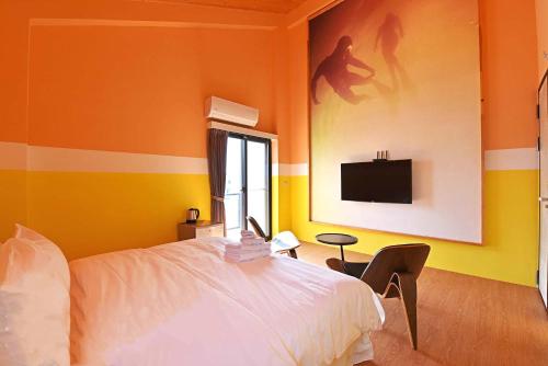 a bedroom with a bed and a tv on the wall at Ocean View Hall B&B in Magong