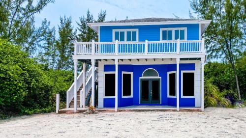 una casa azul y blanca en la playa en Sheer Bliss BeachView Apt #3, en Georgetown