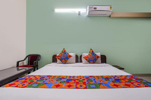 a room with a bed with a colorful blanket on it at FabExpress D Grand in Hyderabad