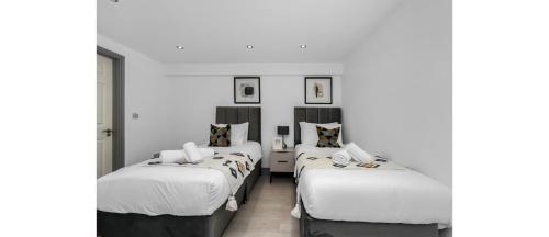 - 2 lits dans une chambre aux murs blancs dans l'établissement Easy Two Bedroom Flat in Hipster Hackney, à Londres