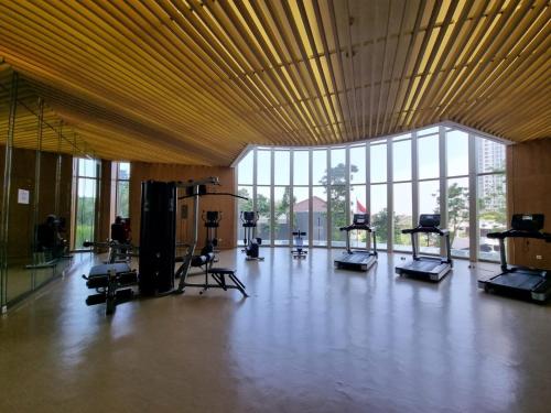 a gym with treadmills and ellipticals in a large building at Gin Residence in Jakarta