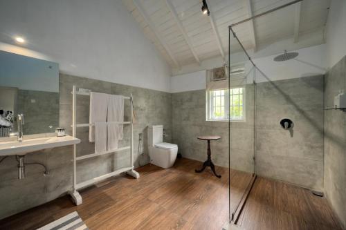 a bathroom with a shower and a toilet and a sink at Ferncliff Bungalow in Nuwara Eliya