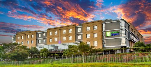 Un edificio con un cielo nuvoloso davanti. di Holiday Inn Express Sandton-Woodmead, an IHG Hotel a Johannesburg