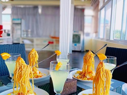 a table with plates of pasta and glasses of milk at Ocean Star Hotel in Koror