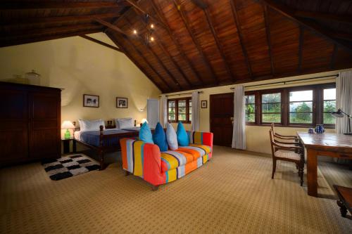 een woonkamer met een bank en een bed bij Ferncliff Bungalow in Nuwara Eliya