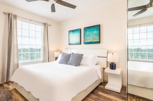 1 dormitorio con 1 cama blanca y 2 ventanas en Pool*Top Floor*Forest Views*Balcony*VistaCay en Orlando