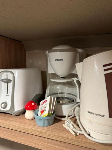 a shelf with a coffee maker and a blender at Le Bouquet Apart Hotel in San Carlos de Bariloche