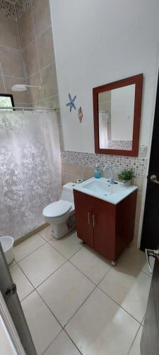 a bathroom with a toilet and a sink at Rancho Lyon Playa Costa Azul in Sonsonate