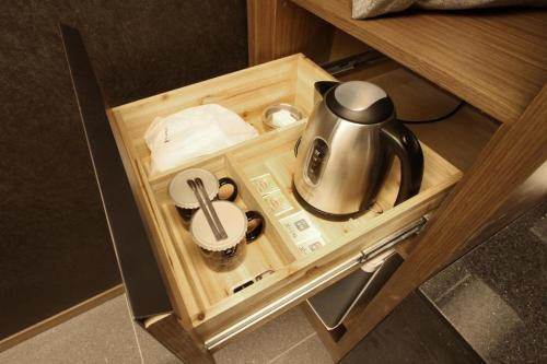 a tea kettle in a wooden compartment in a cabinet at Boutique Hotel K-Oido in Siheung