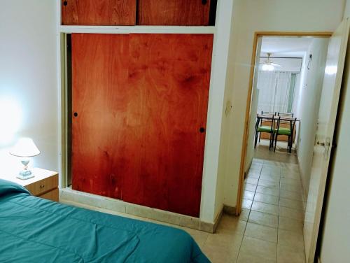 1 dormitorio con puerta corredera roja y mesa en Punta Ninfas 1 en Las Grutas