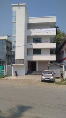 un edificio bianco con un'auto parcheggiata di fronte di Hotel Eden's Garden , Rangat a Sabari