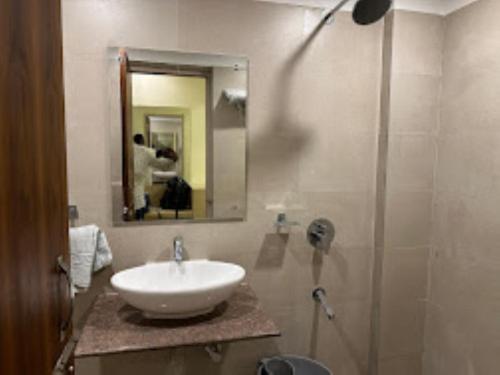 a bathroom with a sink and a shower with a mirror at Hotel Eden's Garden , Rangat in Sabari