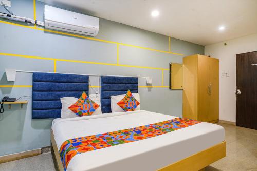 a bedroom with a large bed with colorful pillows at FabHotel JKC Grand in Hyderabad