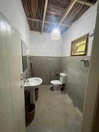 uma casa de banho com um lavatório e um WC em KOMOREBI MADIHA em Madihe East