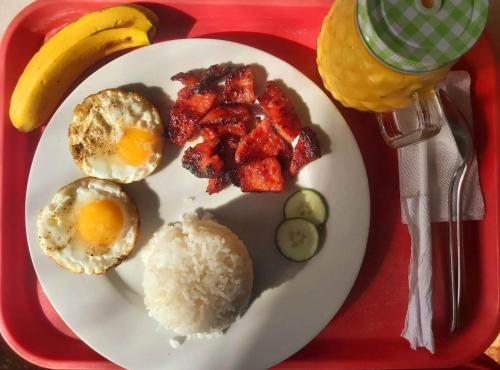 a plate of breakfast food on a red tray at 3 Sisters Guest House 2 in Moalboal