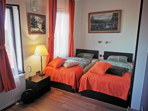 a bedroom with two beds with orange sheets at Private Apartments in Hotel Snezhanka in Pamporovo