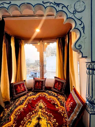 a bedroom with a canopy bed with a window at The Palace View Homestay & Restaurant in Būndi