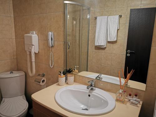 a bathroom with a sink and a phone on the wall at Private Apartments in Hotel Snezhanka in Pamporovo