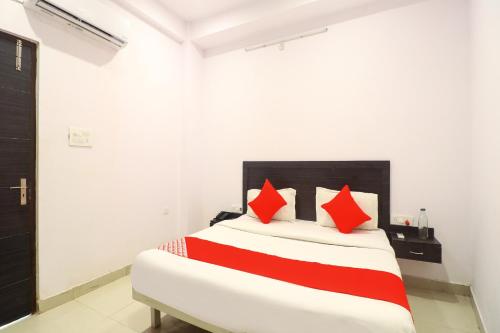 a bedroom with a bed with red pillows at OYO Flagship Metro Inn in Chinhat