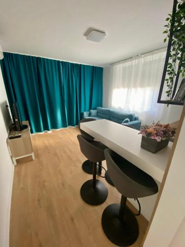a living room with a table and chairs and a couch at PannaRoza Apartman in Balatonlelle