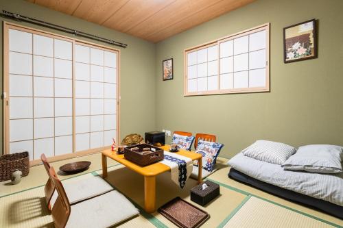 a bedroom with a bed and a table and chairs at 大阪指定特区民泊小田別荘なんば店OdaVillaNamba in Osaka