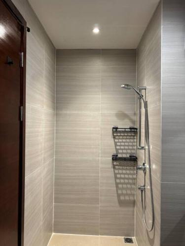 a bathroom with a shower with a glass door at West Vista Studio Apartment with Netflix in Jakarta