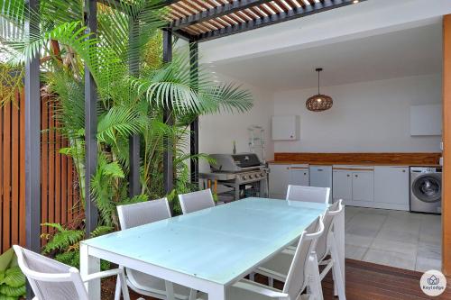 uma cozinha com uma mesa azul e cadeiras brancas em Ti Kaz Bellevue - villa avec vue mer - jacuzzi - Saint-Denis em Saint-Denis