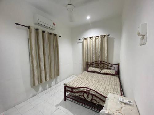 ein kleines Schlafzimmer mit einem Bett in einem Zimmer in der Unterkunft Homestay Selayang D Kepong in Kuala Lumpur